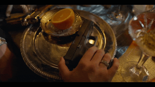 a silver plate with a slice of orange on it and the letters dtn on the bottom
