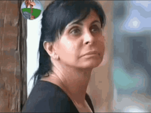 a close up of a woman 's face looking out a window
