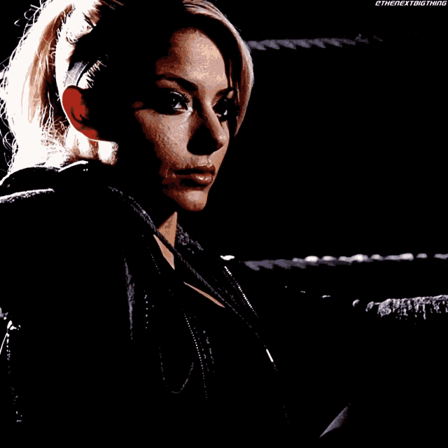 a woman stands in a wrestling ring with the nextbig thing written on the bottom