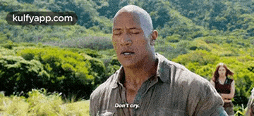 a man is standing in a field with his eyes closed and saying `` don t cry '' .