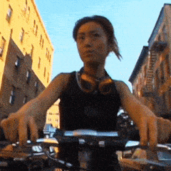 a woman wearing headphones is riding a bike on a city street