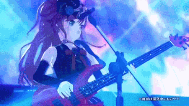 a girl is playing a guitar in front of a microphone .