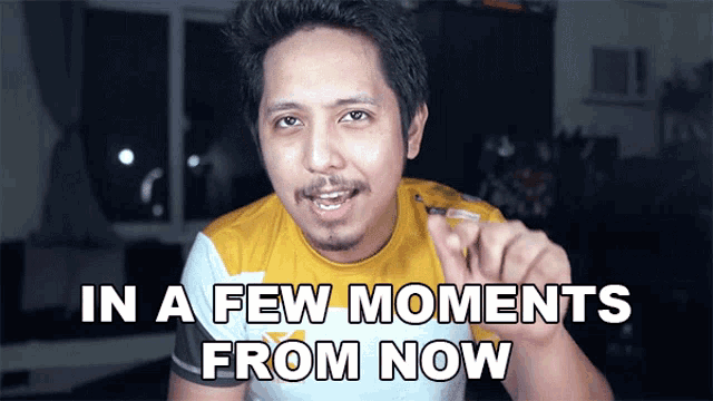 a man says in a few moments from now while pointing at the camera