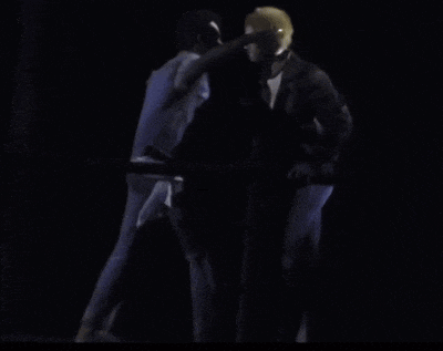 two people hugging in the dark with one wearing a blue jacket