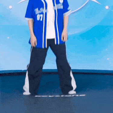 a man wearing a blue jersey with the number 87 on it is standing on a trampoline .