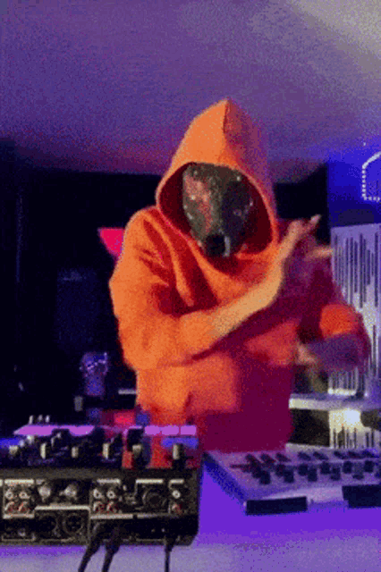 a man wearing an orange hoodie and a mask is dancing
