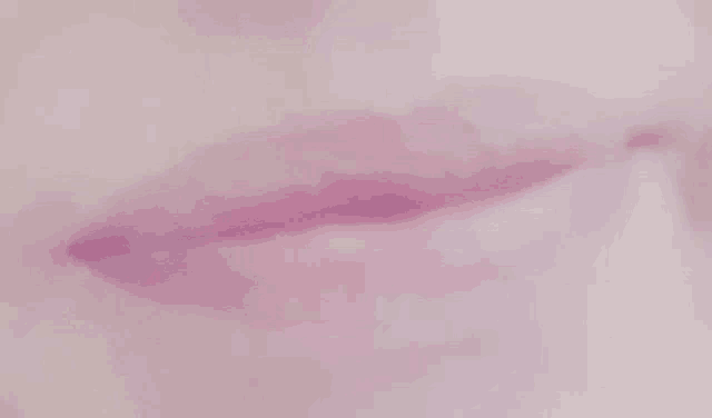 a close up of a person 's mouth with purple lipstick and white teeth