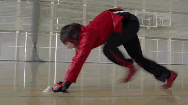 a person in a red jacket is doing a trick on the floor