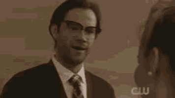 a man in a suit and tie is talking to a woman and says rawr !