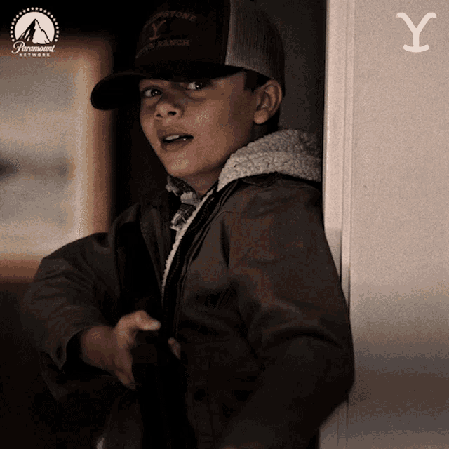 a young boy wearing a hat that says " yellowstone "