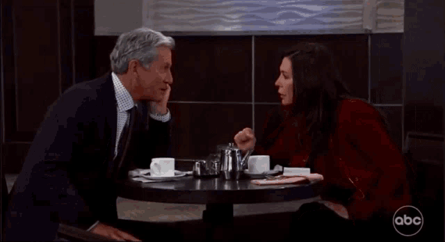 a man and a woman are sitting at a table with abc written on the bottom of the screen