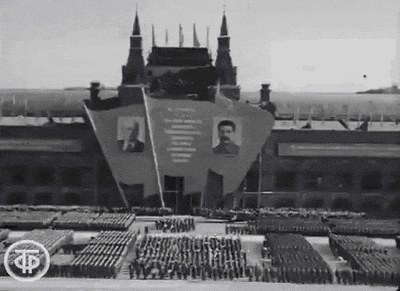 a black and white photo of a military parade in front of a building with the letter p on it