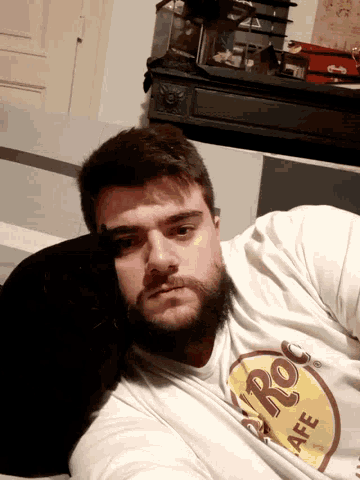 a man wearing a hard rock cafe shirt takes a selfie