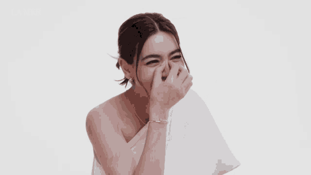 a woman laughs in front of a la mer ad