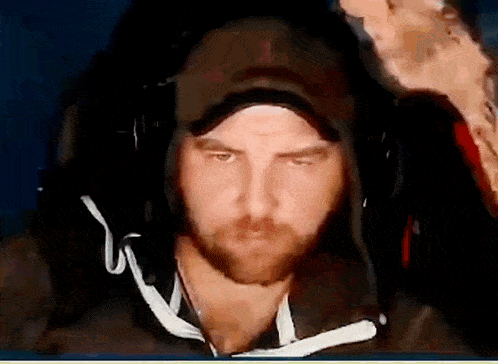 a man wearing a hat and headphones looks at the camera