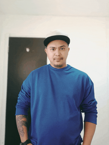 a man wearing a blue sweatshirt and a black hat