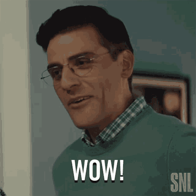a man wearing glasses and a green sweater is saying wow .