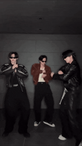 a group of young men wearing sunglasses are dancing together