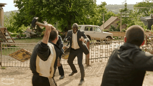 a man in a suit is being attacked by a group of men and the word prime is visible in the corner