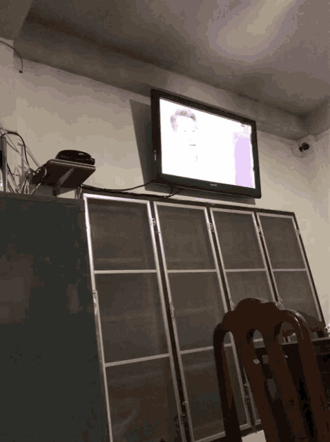 a flat screen tv is mounted to the wall above a shelf