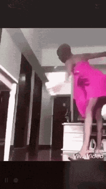 a woman in a pink dress is dancing in a room with the words vivavideo on the bottom