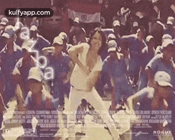 a woman is dancing in front of a crowd of people in a crowd .