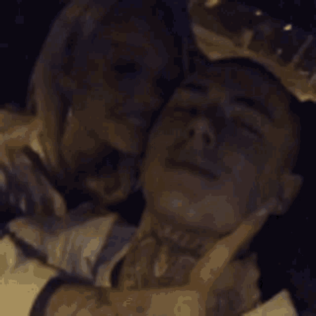 a man with a tattoo on his neck is being held by a woman .