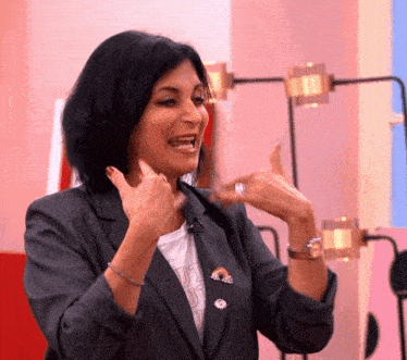 a woman wearing a blazer and a t-shirt that says just do it is smiling