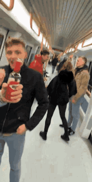 a man in a black jacket is holding a can of coca cola
