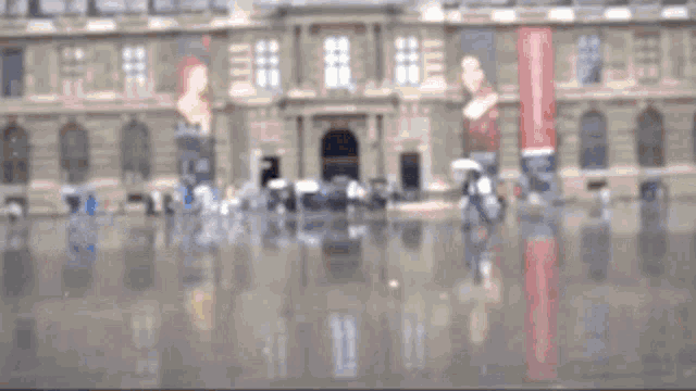 a blurry picture of a woman walking in front of a large building