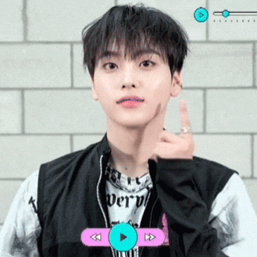 a young man wearing a black jacket and a white shirt with the word very on it is giving the middle finger .