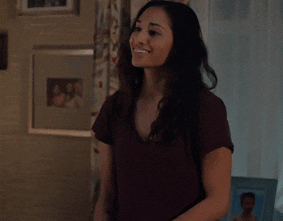 a woman is clapping her hands in a living room in front of a window .