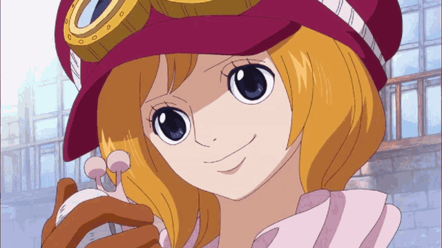 a girl wearing a red hat and goggles smiles