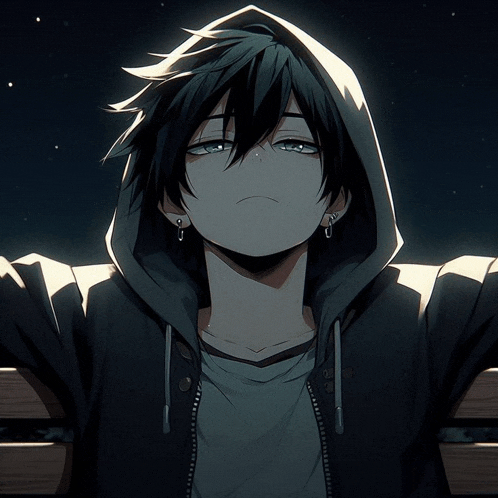 a boy wearing a hoodie and earrings looks down at something