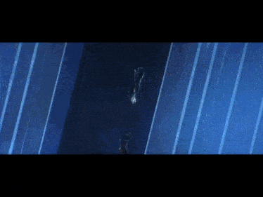 a person is jumping into a dark blue room