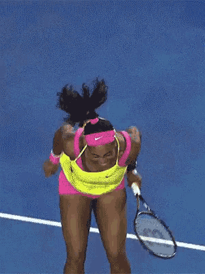 a woman in a yellow dress is holding a tennis racket
