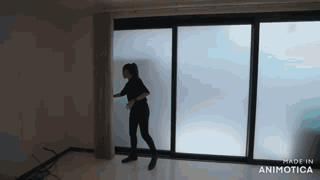 a woman is standing in front of a sliding glass door that says made in animotica