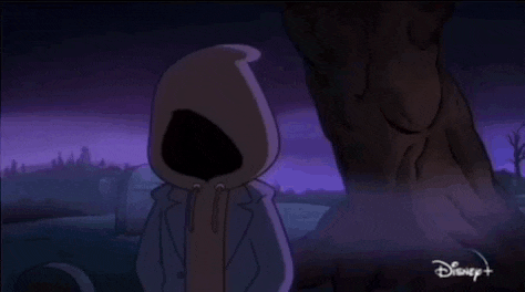 a close up of a cartoon character 's face with a hood and glowing eyes .
