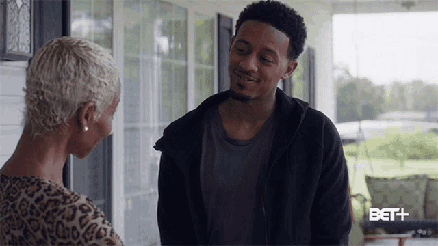 a man and a woman are talking on a porch with bet + written in the corner