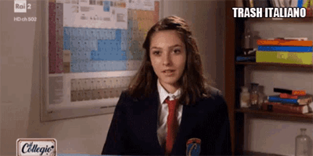 a girl in a suit and tie is sitting in front of a periodic table and the words trash italiano above her