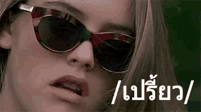 a close up of a woman wearing sunglasses with a foreign language on the bottom .