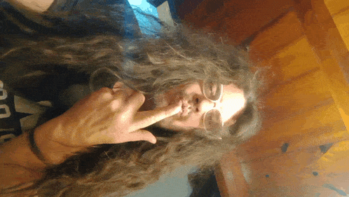 a man with long hair is wearing glasses and a shirt that says ' abercrombie & fitch ' on it