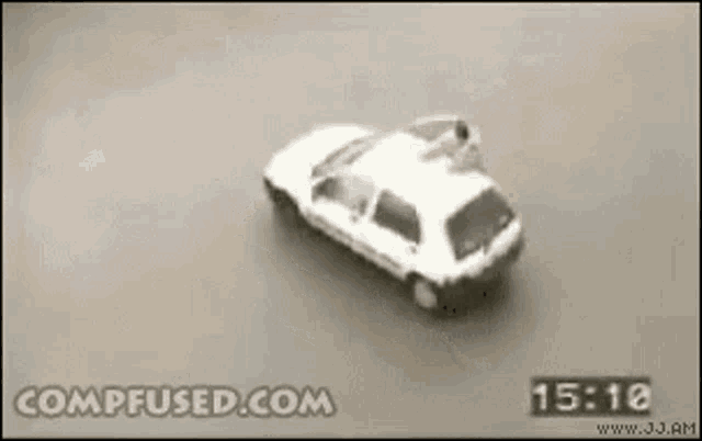 a white car is driving down a road with the time of 15:18 on the bottom