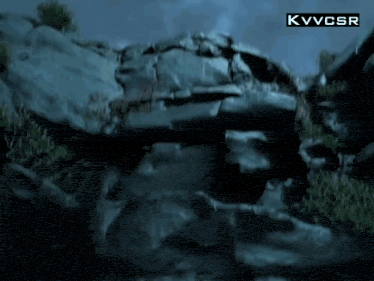 a large rock in the middle of a forest with a kvvcsr logo