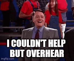 a man in a suit and tie is smiling in front of a crowd and says i couldn t help but overhear .