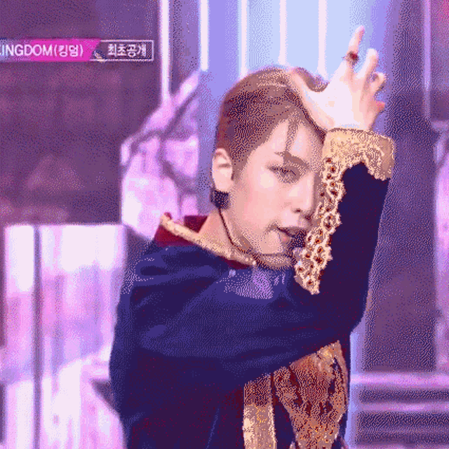 a man in a blue and gold outfit is performing on a stage with a sign that says kingdom