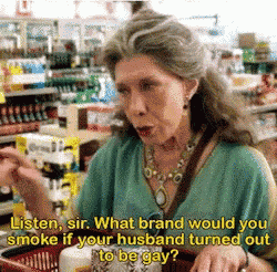 a woman in a green shirt is talking to someone in a grocery store .