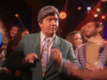 a man in a green suit and tie is dancing in a club