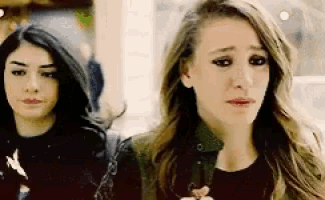 two women are standing next to each other one is crying and the other is smiling