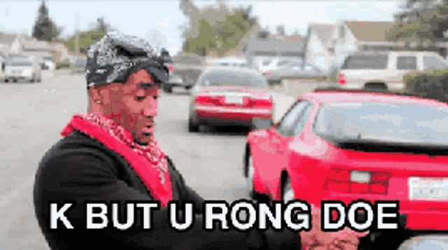 a man standing next to a red car with the words k but u rong doe